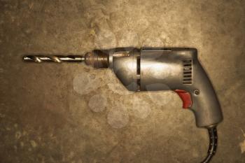 Royalty Free Photo of an Electric Drill Resting on a Cement Floor