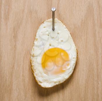Royalty Free Photo of a Fried Egg Bailed to Wood