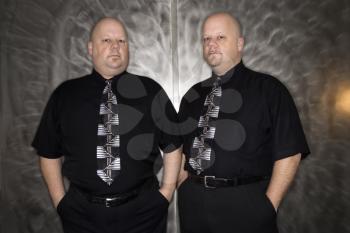 Royalty Free Photo of Bald Identical Twin Men Standing Together