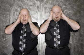 Royalty Free Photo of Twin Men Covering Their Ears