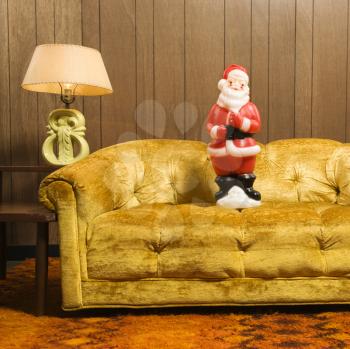 Santa clause figurine on retro style couch.