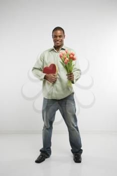 Royalty Free Photo of a Man Holding a Valentine Heart and Bouquet of Tulips Smiling