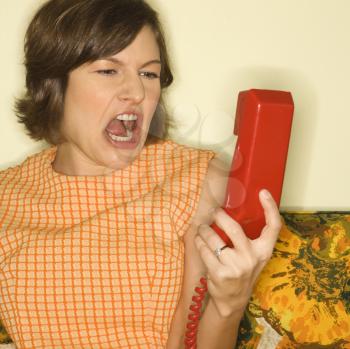 Royalty Free Photo of a Woman Screaming at a Red Telephone Receiver.