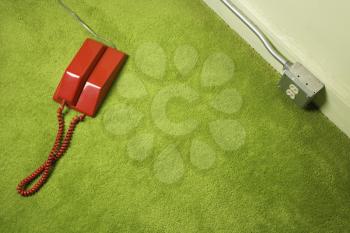 Royalty Free Photo of a Red Vintage Telephone on a Green Carpet