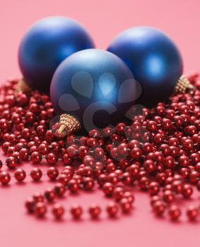 Royalty Free Photo of Christmas Ornaments and Strings of Red Beads