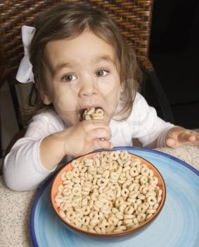 Royalty Free Photo of a Girl Eating a Bowl of Cereal