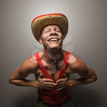 Royalty Free Photo of a Man Wearing a Straw Hat and Touching His Chest