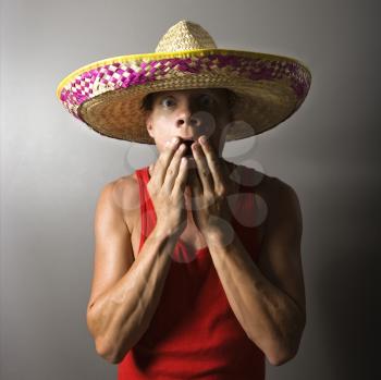 Royalty Free Photo of a Male Wearing a Sombrero With Hands Over Mouth