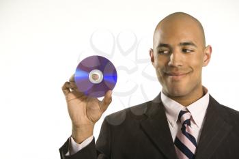 Royalty Free Photo of a Man Smiling Holding Out a Compact Disc