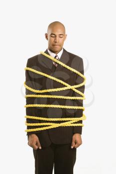 Royalty Free Photo of a Businessman Wrapped in Yellow Rope