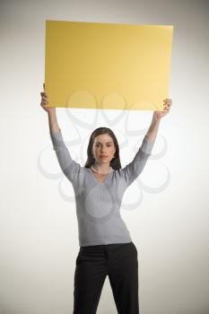 Royalty Free Photo of a Businesswoman Holding Up a Sign