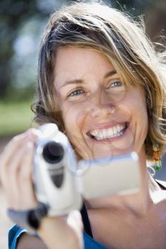 Royalty Free Photo of a Woman Outdoors Holding a Video Camera