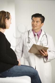 Royalty Free Photo of a Doctor Examining a Pregnant Female Patient