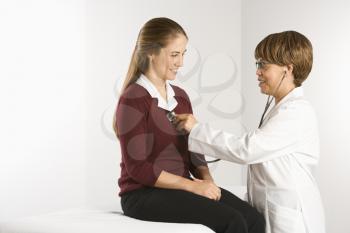 Royalty Free Photo of a Doctor Examining a Patient With a Stethoscope