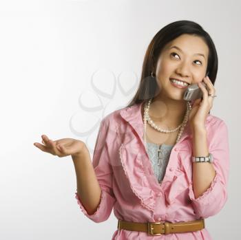 Royalty Free Photo of a Portrait of an Asian Chinese Female Smiling and Talking on a Cell Phone
