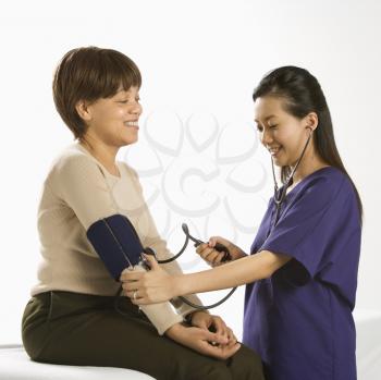Royalty Free Photo of a Female Medical Practitioner Checking Blood Pressure of a Female Patient
