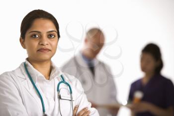 Royalty Free Photo of a Doctor Standing With Medical Staff in the Background