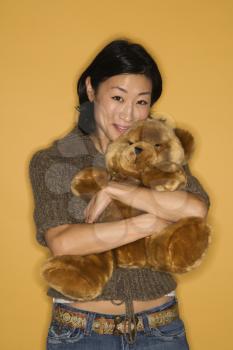 Royalty Free Photo of a Pretty Woman Hugging a Brown Teddy Bear
