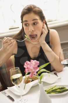 Royalty Free Photo of a Woman Making an Exaggerated Expression While Eating