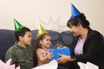 Royalty Free Photo of a Mother Giving a Present to Her Daughter at a Birthday Party