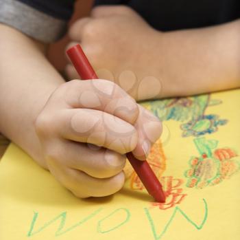 Royalty Free Photo of a Boy Drawing With Crayons
