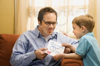 Royalty Free Photo of a Boy Giving His Father a Drawing