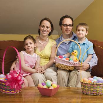 Royalty Free Photo of a Family Sitting on a Couch Holding Easter Baskets and Smiling