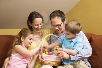 Royalty Free Photo of a Family on a Couch Looking at an Easter Basket