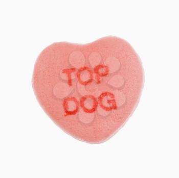 Pink candy heart that reads top dog against white background.