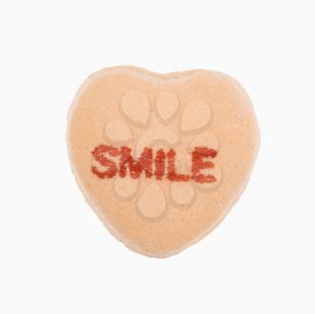 Royalty Free Photo of an Orange Candy Heart That Reads Smile