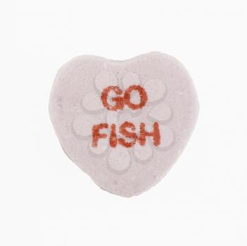 Purple candy heart that reads go fish against white background.