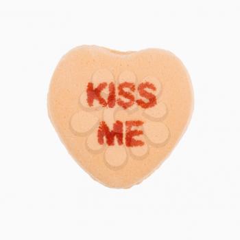 Royalty Free Photo of an Orange Candy Heart That Reads Kiss Me