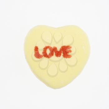 Royalty Free Photo of a Yellow Candy Heart That Reads Love