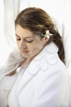Royalty Free Photo of a Pretty Woman Wearing a White Terry Robe With a White Orchid Flower in Her Hair