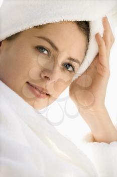 Royalty Free Photo of a Woman Wearing a Robe and Towel on Her Head With Hand to Head