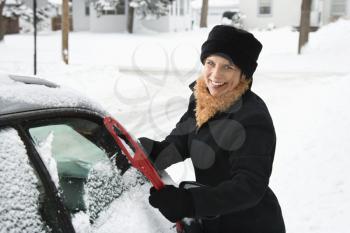 Royalty Free Photo of a Woman Scraping Ice Off a Car Windshield