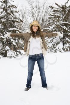Royalty Free Photo of a Female Standing and Playing in the Snow Wearing a Straw Cowboy Hat