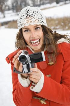 Royalty Free Photo of a Woman Holding a Video Camera and Smiling