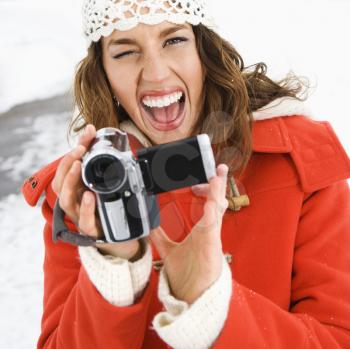 Royalty Free Photo of a Woman Holding a Video Camera and Winking