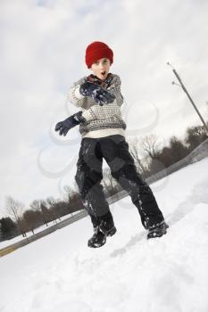 Royalty Free Photo of a Boy Wearing a Sweater and Red Winter Cap Gesturing With Arms and Hands