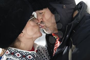 Royalty Free Photo of a Man and Woman in Winter Clothing Kissing