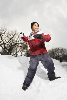 Royalty Free Photo of a Boy Standing in Snow Throwing a Snowball