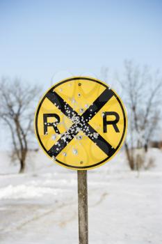 Royalty Free Photo of a Railroad Crossing Sign in as Snow Covered Rural Landscape