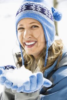 Royalty Free Photo of a Woman Wearing a Ski Hat and Gloves Holding a Snowball