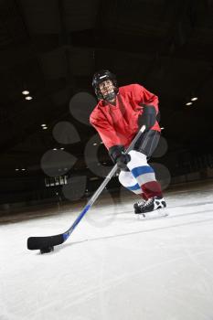 Royalty Free Photo of a Female Hockey Player Skating on Ice Lining Up to Shoot Puck