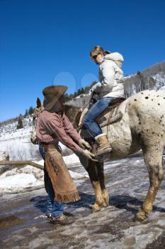 Royalty Free Photo of a Wrangler Talking to a Woman on Horseback