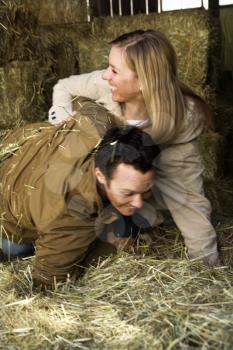 Royalty Free Photo of a Young Couple Playing in Hay