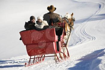 Royalty Free Photo of a Man Driving a Horse Drawn Sleigh With a Young Couple