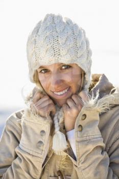 Royalty Free Photo of a Woman in Winter Attire Holding Her Collar and Smiling