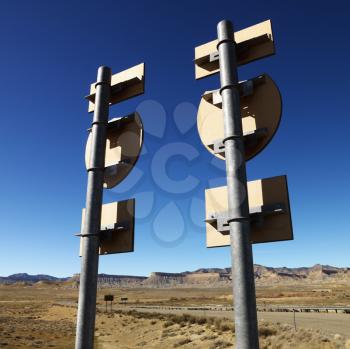 Royalty Free Photo of Two Road Signs on a Post With Guardrail and Mountains in the Background